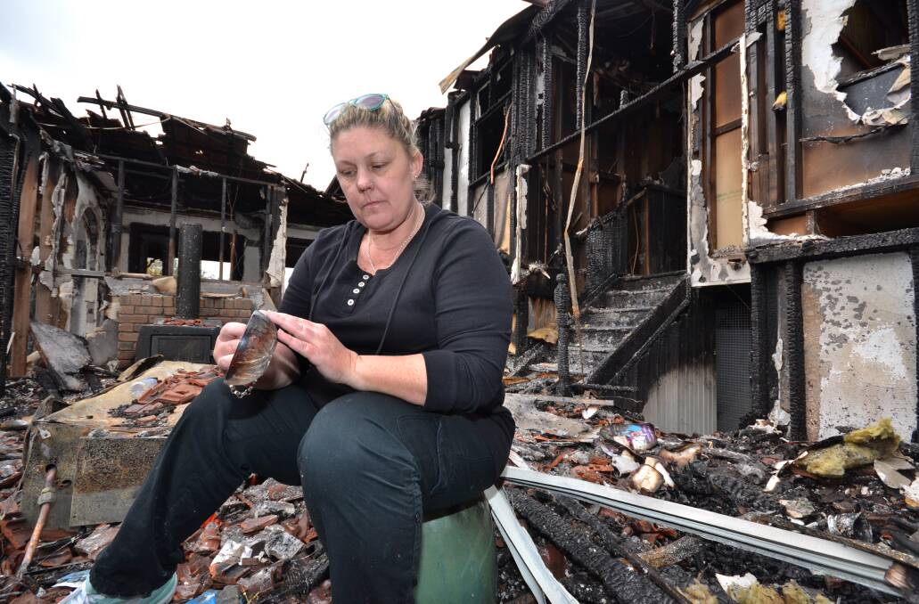 DEVASTATION: Allison Hokin sits in the destroyed living area of her parents’ Cavanagh Lane home that was gutted by fire last Thursday. Shoalhaven residents are rallying to organise fund-raising events for the couple who lost everything in the blaze.