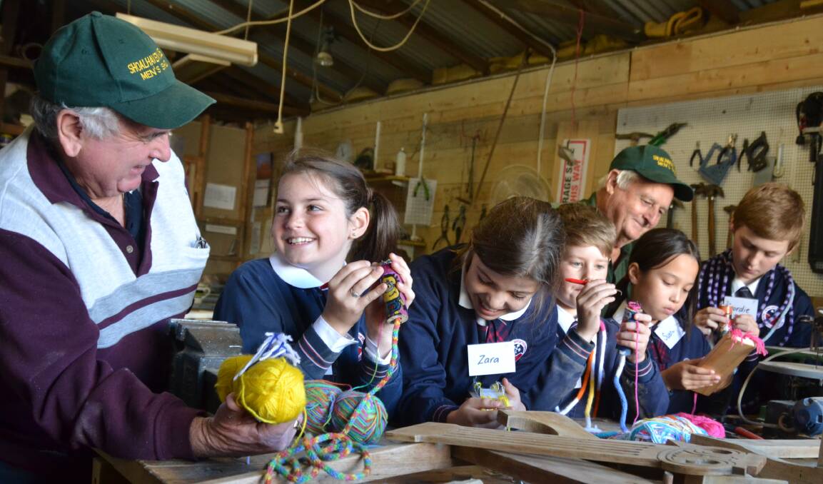 OLD SCHOOL: Bill Owens and Rob Dines from the Shoalhaven Heads Men’s Shed chat with Nowra Anglican College students Abby Bice, Zara Capner, Baxter Scully, Sushada Alexander and Geordie Schreurs about their Knitting Nancy project.