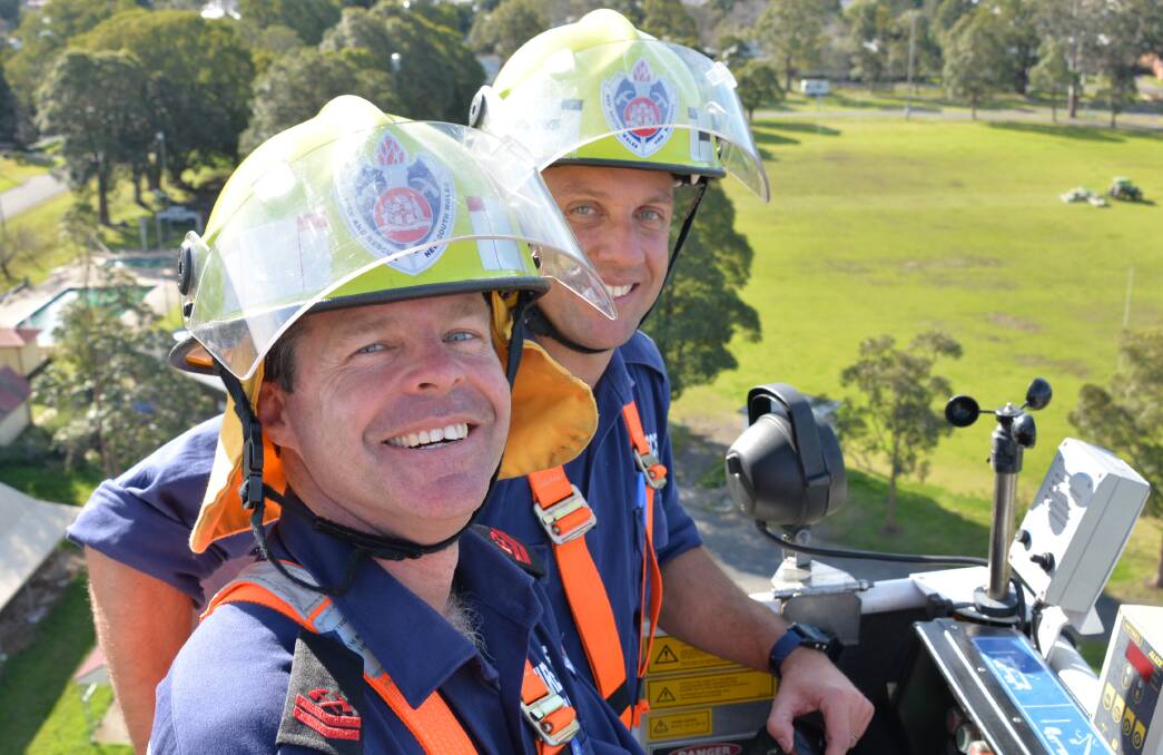HIGH TIME: Fire and Rescue NSW retained firefighter at Berry Station 224 Ross Goodger and Wollongong firefighter Stuart James take an aerial view of Berry Showground in a ladder platform fire truck ahead of the Regional Firefighter Championships this weekend. 
Photo: JESSICA LONG