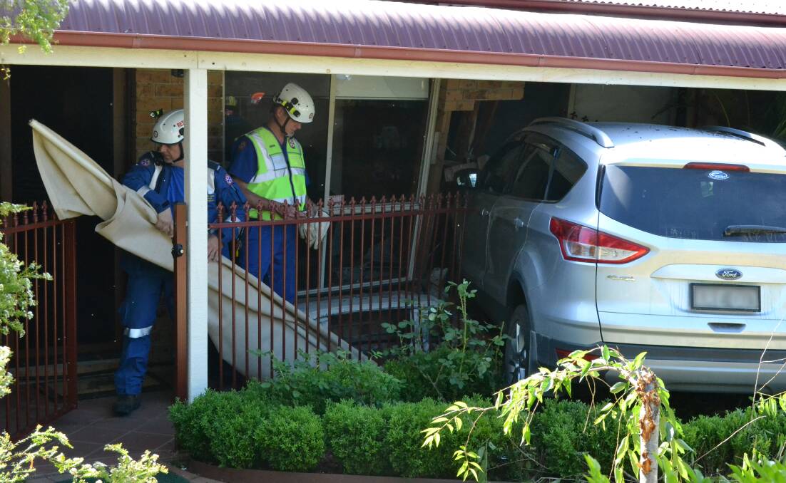 WRECKED: The car hit a school bus before crashing through a hedge and into the front of the house.
