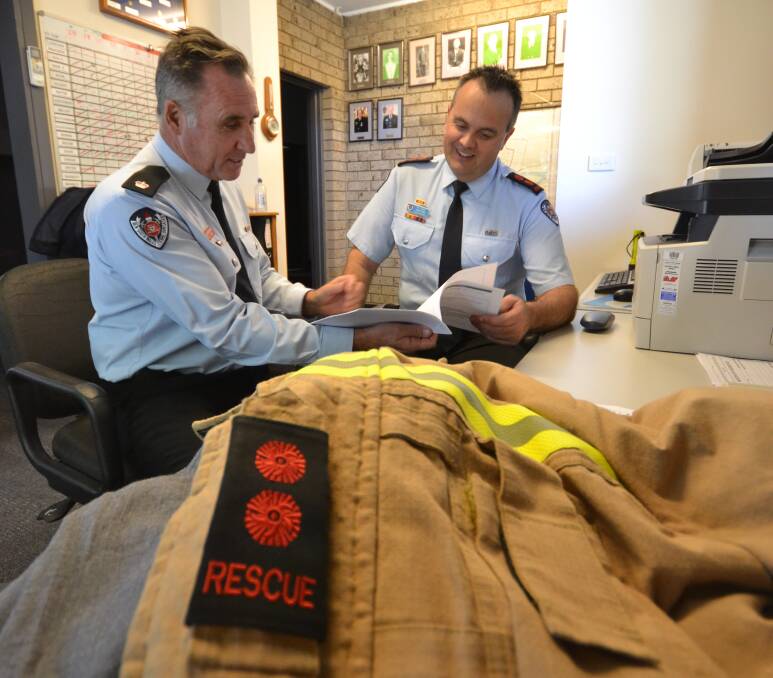 FIRE CHIEF: Fire and Rescue NSW Region South Inspector Norman Buckley congratulates Nowra’s recently appointed new fire captain John Dun.