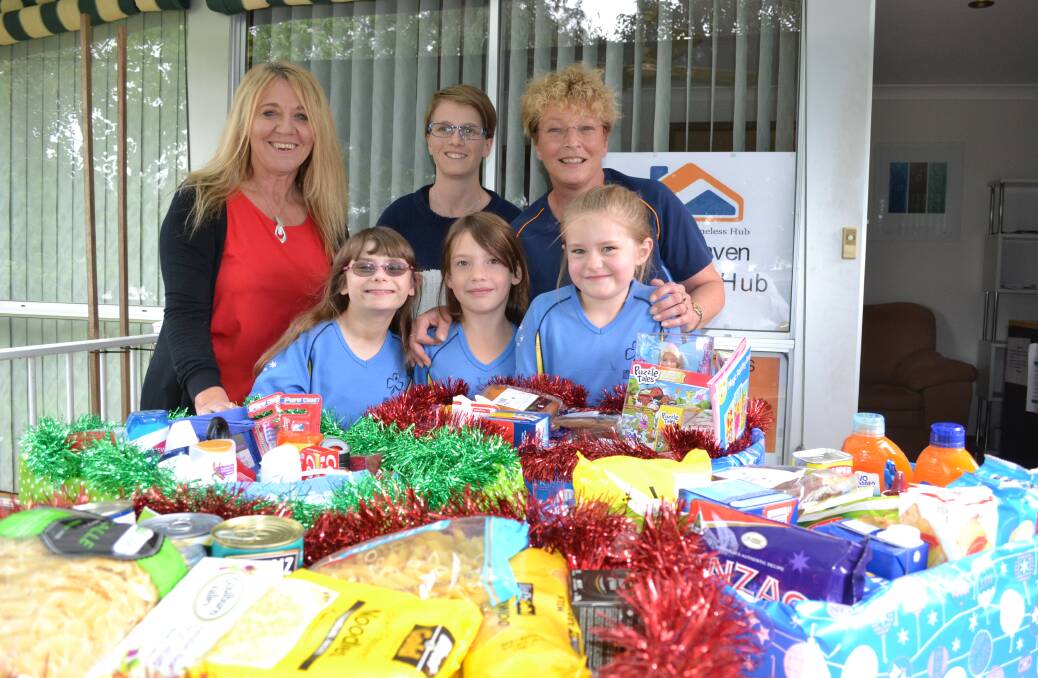 HAMPERS: Shoalhaven Homeless Hub co-ordinator Julie Bugden accepts Christmas hampers from the North Nowra Gumnut Guides, leader Wombat Julie McQuarters, volunteer Ash McQuarters and members Jade Murphy (9), Abby Benson-Stevens (7) and Katie Halliday (6).