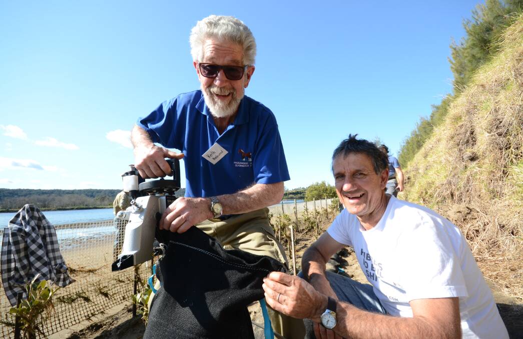 TEAMWORK: Keith Hazlewood and Peter Lawrence sew sandbags to help reduce erosion on the banks of the Shoalhaven River.