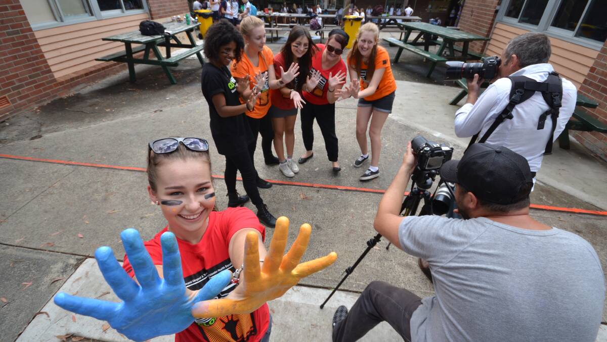 BRIGHT IDEA: Photographers film Nowra High School’s Close the Gap Day event while year 12 student Sarah Blank puts her hands forward.