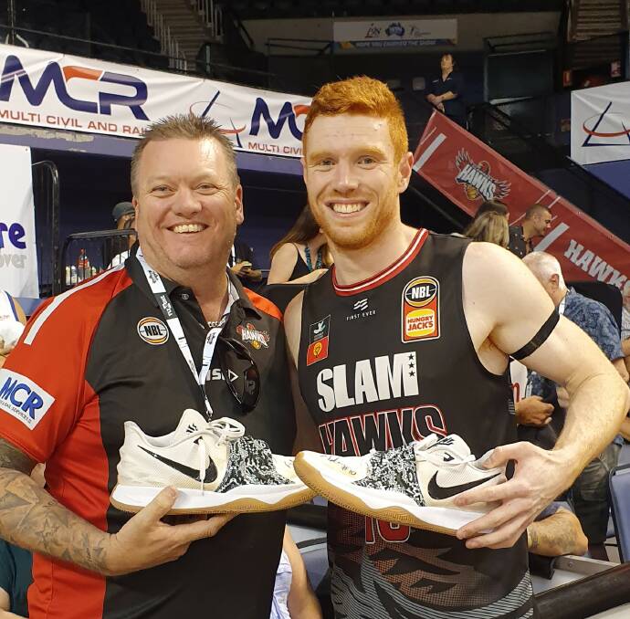IF THE SHOE FITS: Club supporter and sponsor Kevin Boughton who donated $1000 for the Salvos for a signed pair of Angus Glover shoes. 