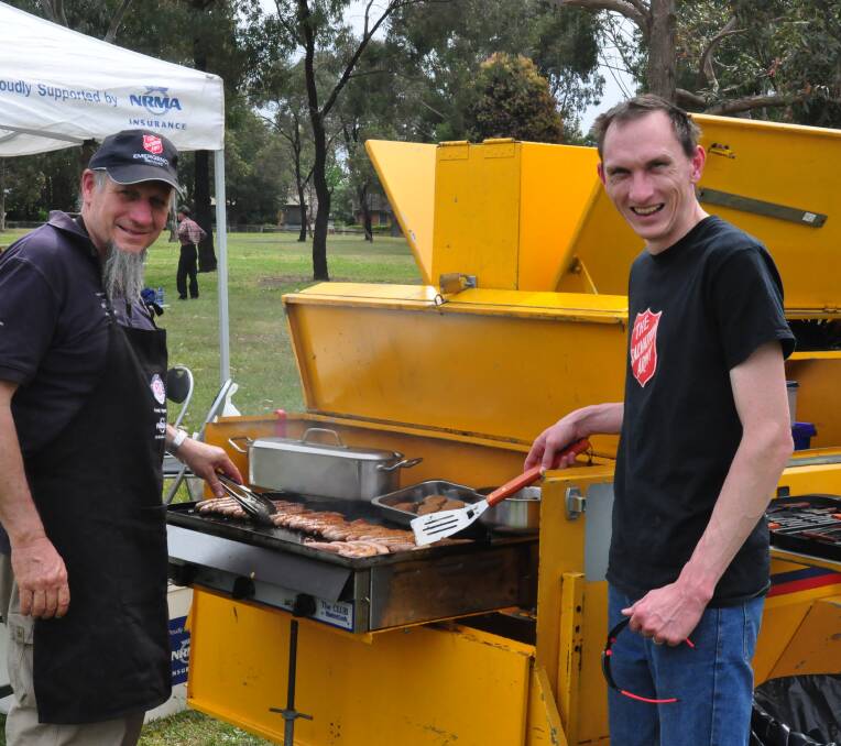 COOK IT UP: Major Garry Johnson and Lieutenant Matthew Sutcliffe from the Salvation Army work hard at the Prosperity in the Park event.