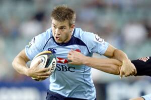 HERE WE COME: Local rugby fans can expect some great action when the NSW Waratahs bring a Super Rugby trial to the Shoalhaven early next year.  Drew Mitchell is pictured taking on the Sharks’ defence last season.