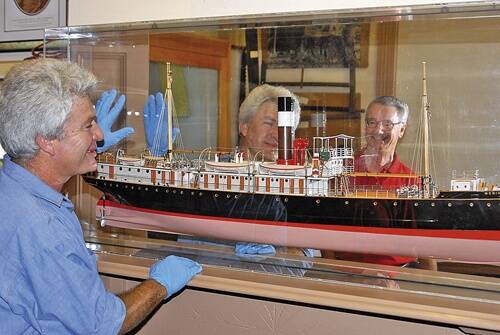 DETAILS: Timothy Morris from the Powerhouse Museum installs the model of the steamer Merimbula under the watchful eye of history society member Colin Jack. Photo: ROBERT CRAWFORD