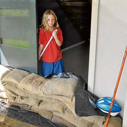PROTECTED: Safe behind sand bags, Lucy Bell still had to help mop up the water that entered her Culburra Beach home yesterday when a sudden downpour flooded a nearby creek.