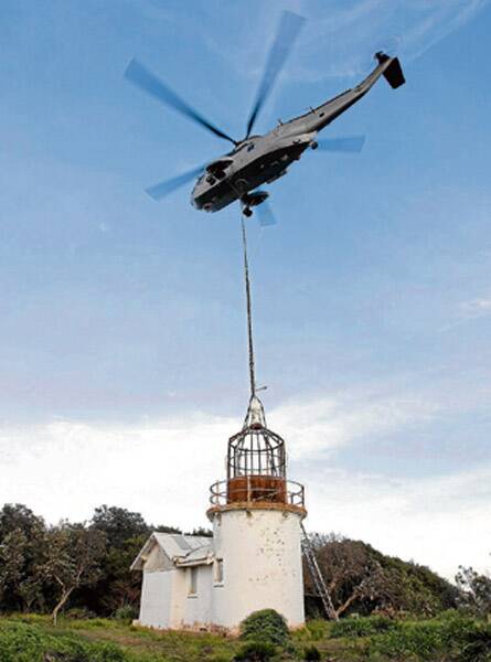 HEAVY WORK: The Shark 22 Sea King from 817 Squadron lifts the lantern off Crookhaven Lighthouse. The lantern was taken to the South Coast Correctional Centre for restoration.