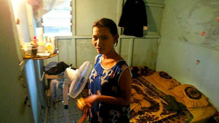 A captive sex worker in the room where she lives and works on the Indonesian island of Batam. Photo: Peter Morris