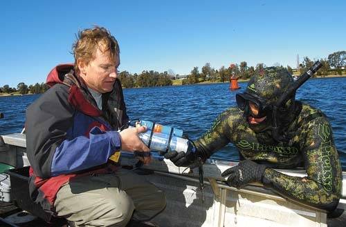 MARINE PROJECT: Estuarine biologist Chris Walsh and Fisheries technician Dylan Van Der Meulen collect data from one of the receivers in the Shoalhaven River.