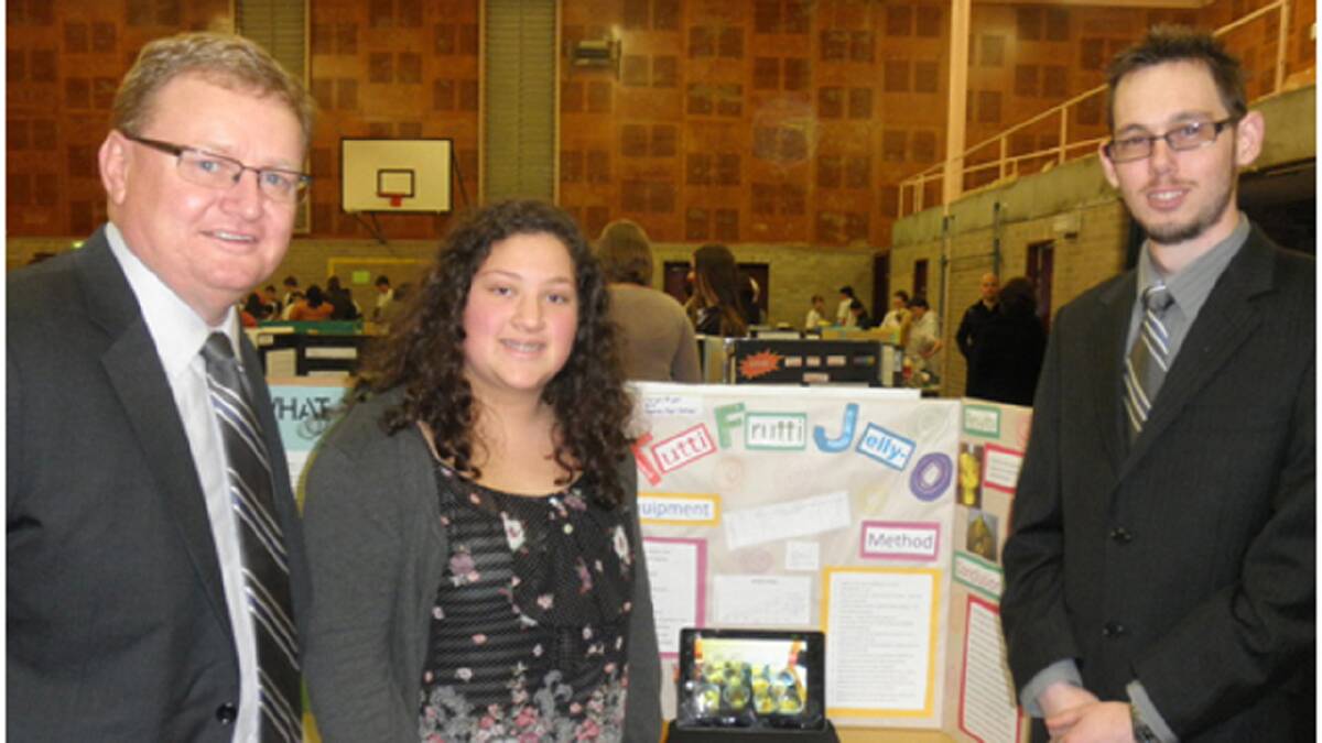EXPERIMENTAL: John J Lamont and chemist Jye Giddings are impressed with a Nowra High School student Jaiya Ariel’s science project at the recent Nowra High School Science Fair.