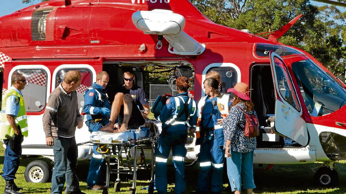INJURED: A 73-year-old Vincentia man suffering chest injuries after being struck by a camper van while cycling on Huskisson Road on Thursday morning is loaded aboard the Ambulance Rescue helicopter.