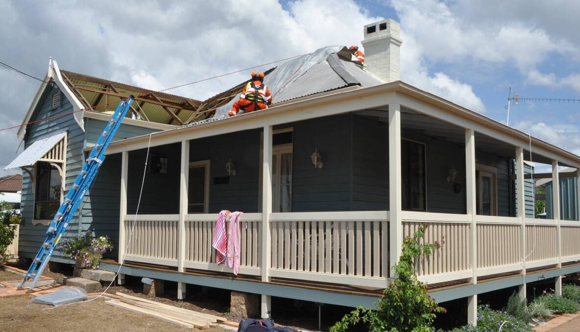 URGENT WORK: SES work to cover this roof in Keft Avenue, Nowra with a tarp. 