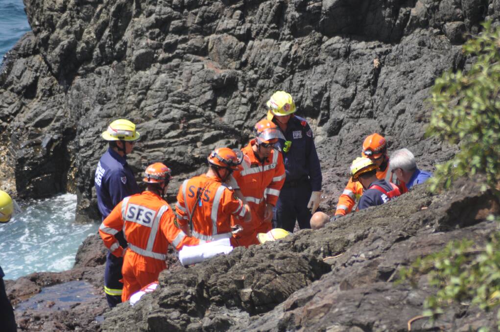 SES volunteers and Fire and Rescue NSW's Kiama unit prepare to extract the diver after he was rescued from Storm Bay. Picture: DANIELLE CETINSKI