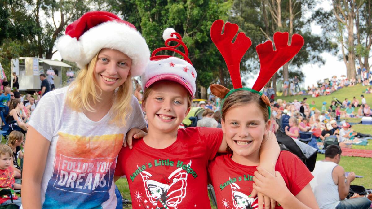 FESTIVE: Emily Laing, Zoe and Amy Baker from St Georges Basin dress festively for Carols by Candlelight in Harry Sawkins Park on Sunday.