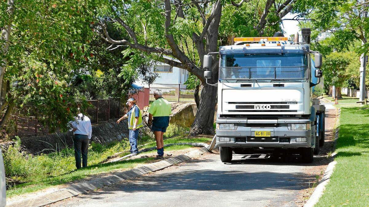 WITHOUT A PADDLE: Shoalhaven Water staff work to clear a sewage overflow from Marriott Park.