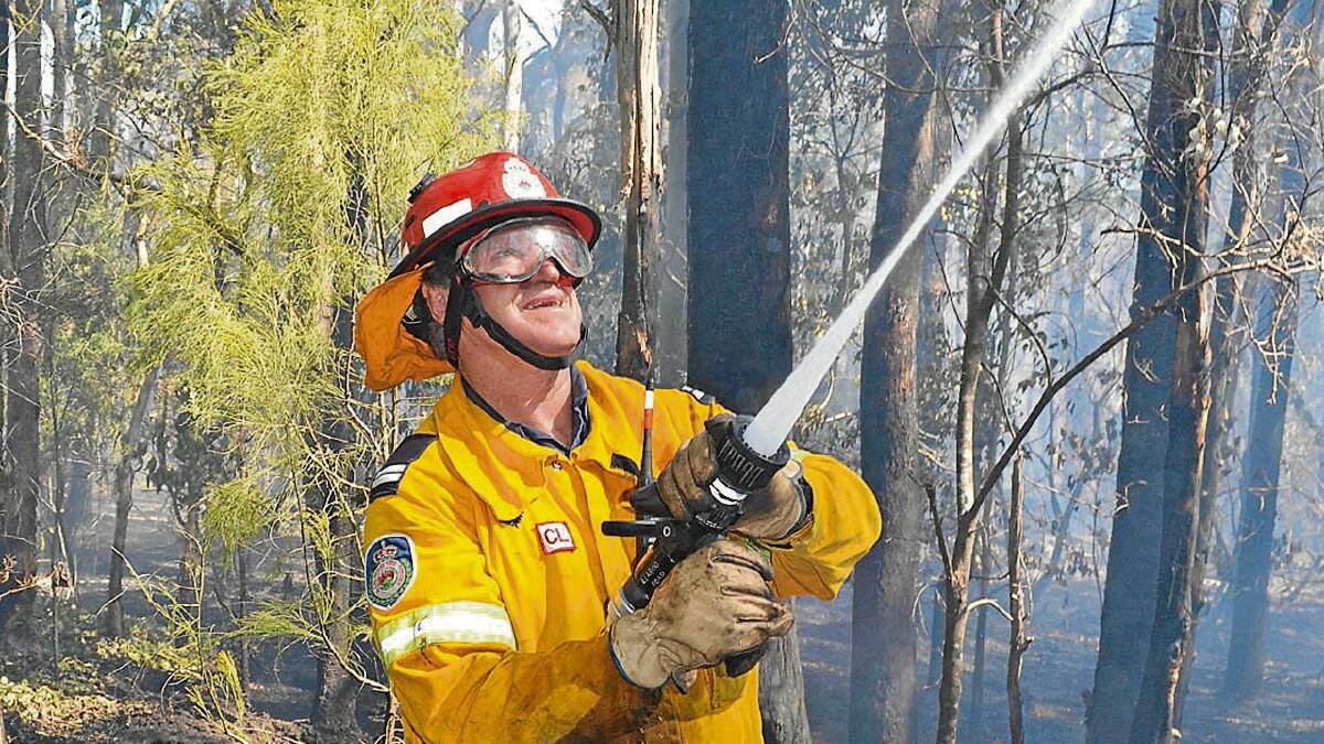 BLACKOUT: Senior deputy Michael Evans from the Illaroo Road Rural Fire Brigade helps knock down flare-ups after the height of the fire.