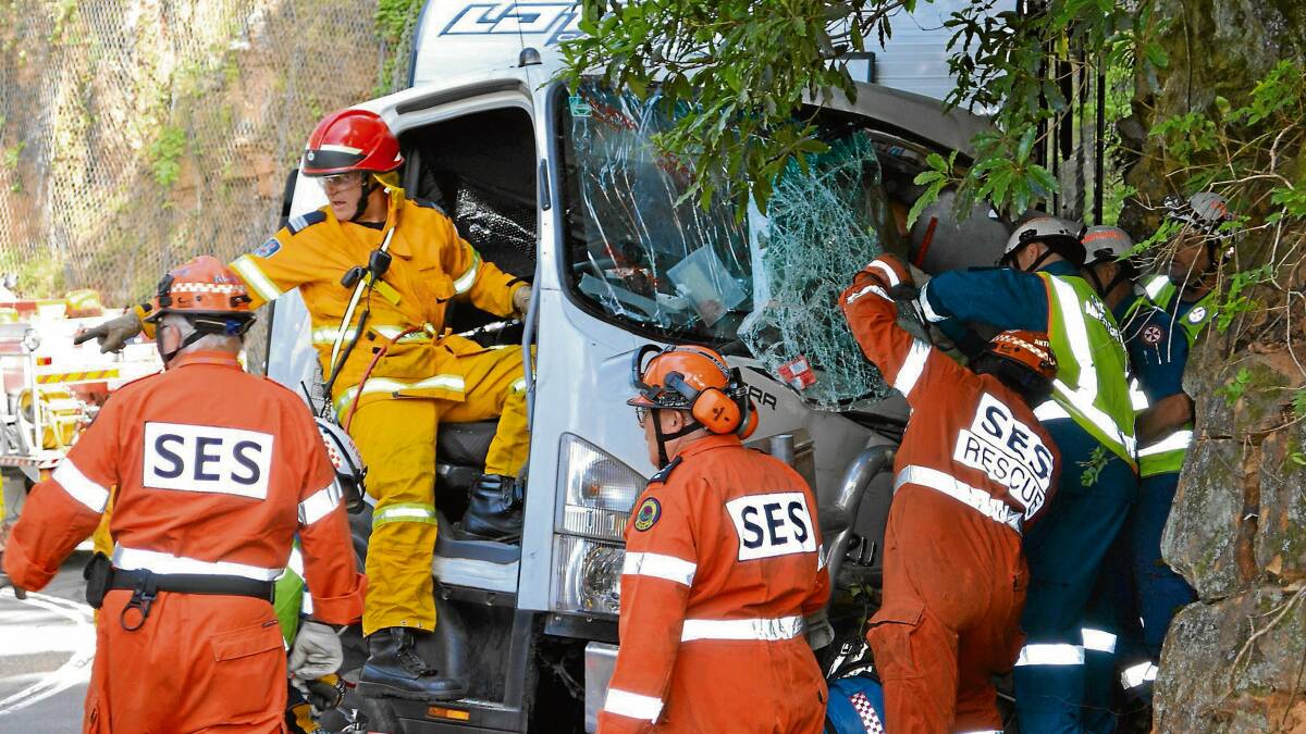 CRASH SCENE: Emergency services crews work to free the trapped truck passenger.