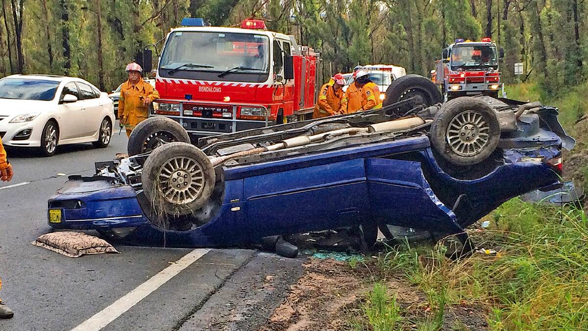 DAMAGED: The upturned Ford Falcon that crashed on the Princes Highway at Jerrawangala on Thursday.