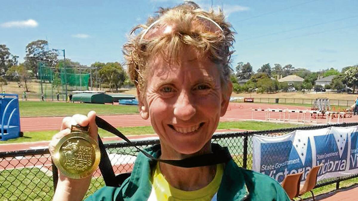GOLDEN GIRL: Cambewarra’s Cristine Suffolk shows off one of her medals from the Oceania Masters Athletic Championships.