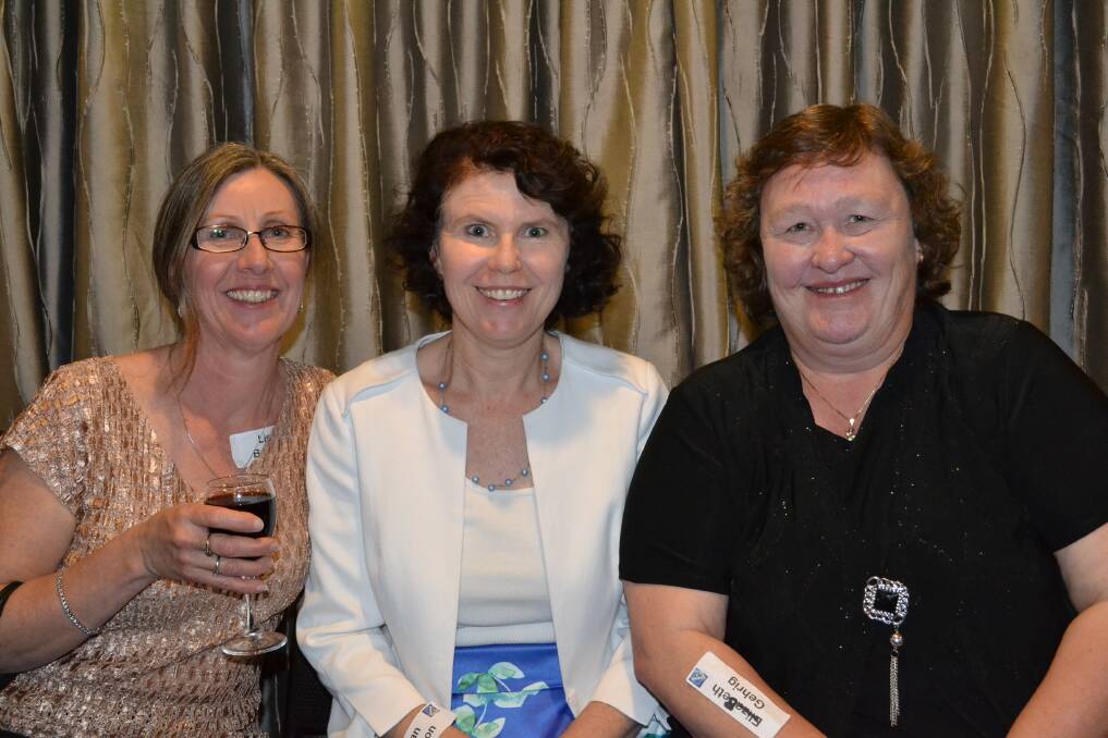 SCHOOL PHOTOS: Lisa Brooks from Batemans Bay, Jillian Morison from Sydney and Beth Gehrig from Vincentia look at school photos at the Nowra High School 50th birthday reunion at Bomaderry Bowling Club on Saturday night.