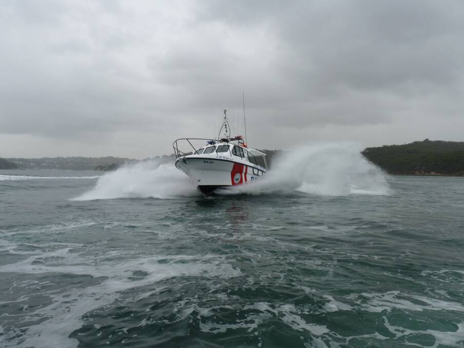 A Marine Rescue vessel searches for a fisherman missing in rough seas off Currarong.