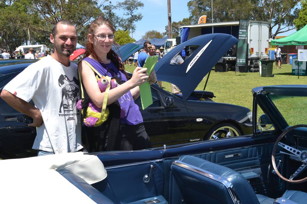 CAR SPOTTING: Fans Jarod Leatham and Jessica Free from Milton enjoy the cars on show at HMAS Albatross on Sunday to help raise funds for research into juvenile diabetes and the Australian Leukodystrophy Support Group.  