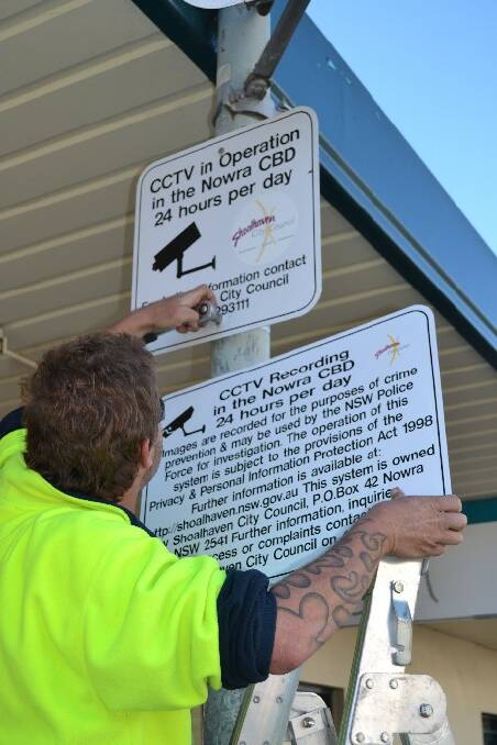 Shoalhaven City Council Northern Shoalhaven Maintenance crew member John Courtney replaces the old CCTV camera signs in Nowra’s Junction Court.   