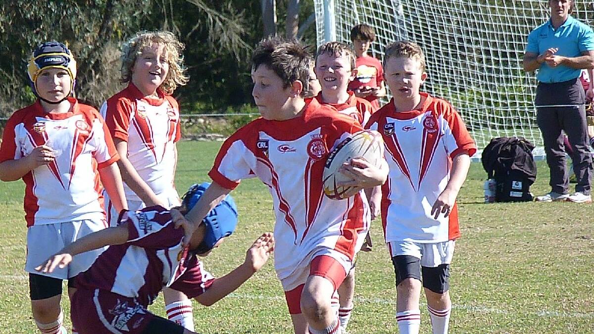 EDEN: Eden Tiger David Swires has his Under 10 team mates smiling as he shrugs off a Tathra Sea Eagles  tackle.