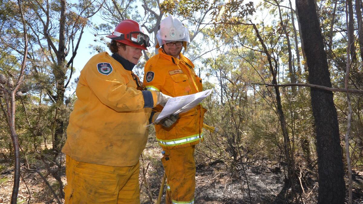 Jacquie Cox and Bryan Green from Callala Beach RFS brigade start the process of blacking out hotspots on the Wandandian fire ground.