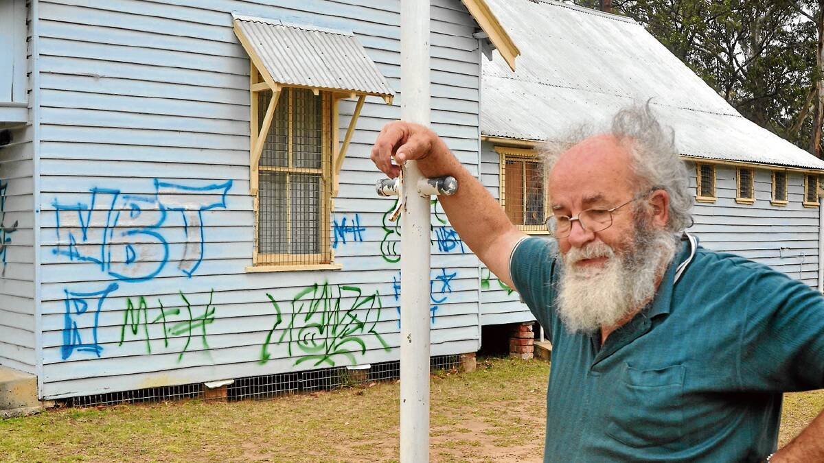 SENSELESS ACT: Bernie Smith confronts the sight of the vandalised First Nowra Scout’s clubhouse.