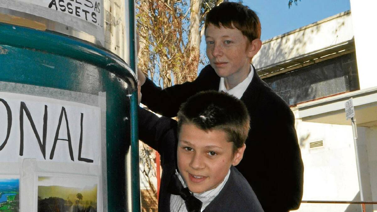 SIGNS OF THE TIMES: Greg Stanton and Jacob Le Pla of Nowra check out signs promoting the importance of trees, ahead of the large Junction Court gum being cut down.