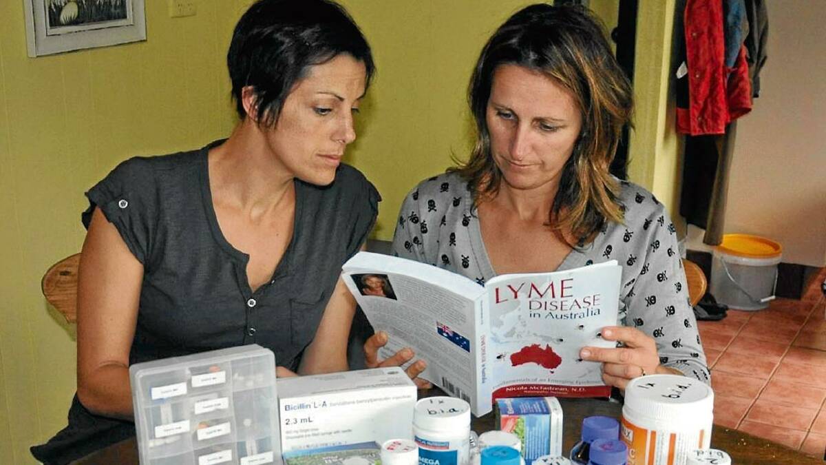RAISING AWARNESS: Melanie Lattanizo (left) from Nowra with her sister (who did not want to be named) and one month’s worth of medication needed to fight Lyme disease.