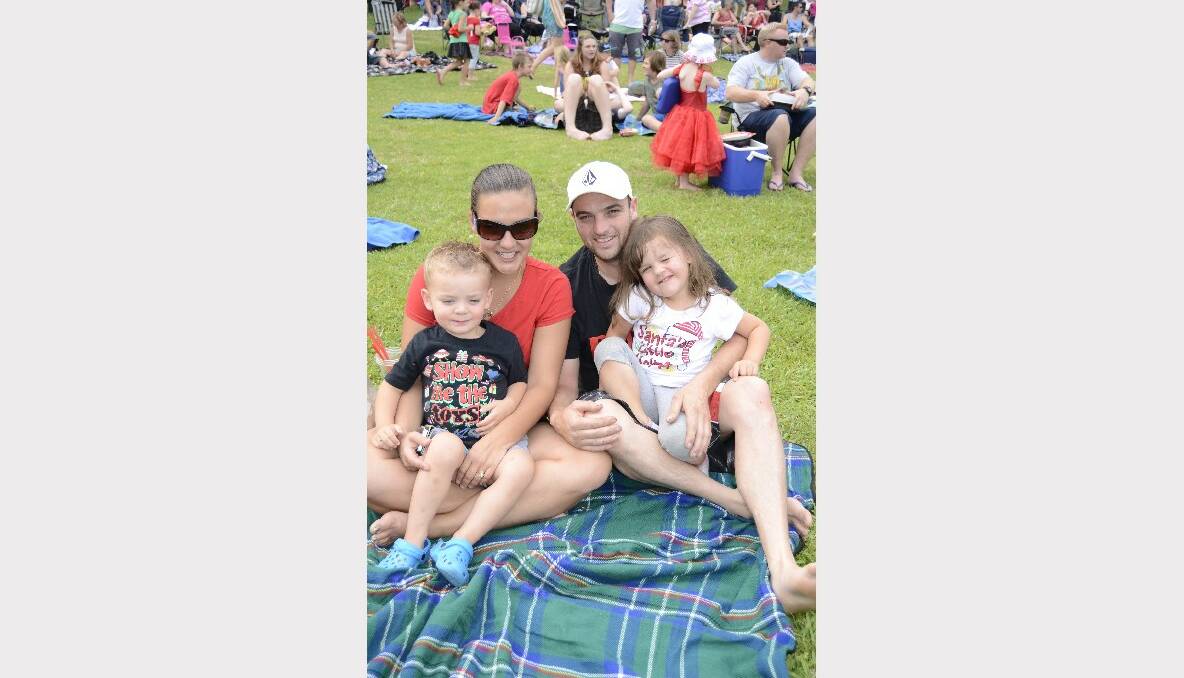 JINGLE BELLS: Stacey, Troy, Zane and Chloe Farrugia from Nowra find a good spot to watch the show at Carols by Candlelight in Harry Sawkins Park on Sunday.