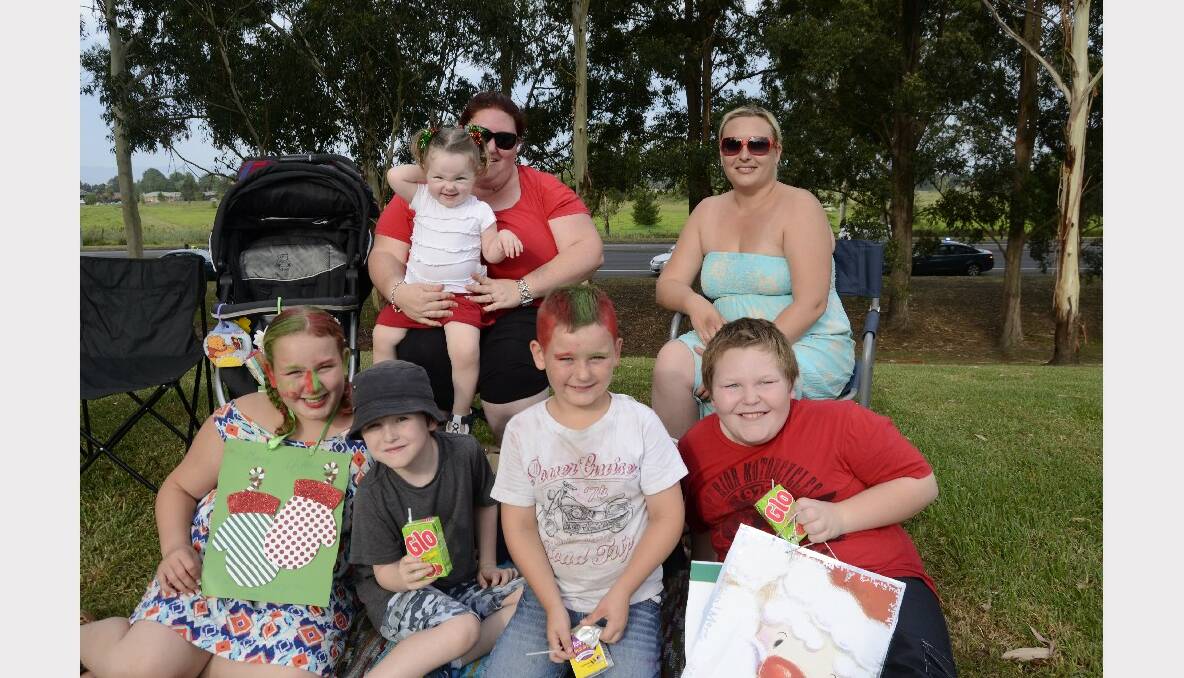 ODE TO JOY: (front) Chloe Bottleheart, Connor Christian, Harold Bottleheart, Ashley Christian, (back) Madleyn Christian, Angela Christian and Tabitha Hart all from Nowra ready to sing along at Carols by Candlelight in Harry Sawkins Park on Sunday.