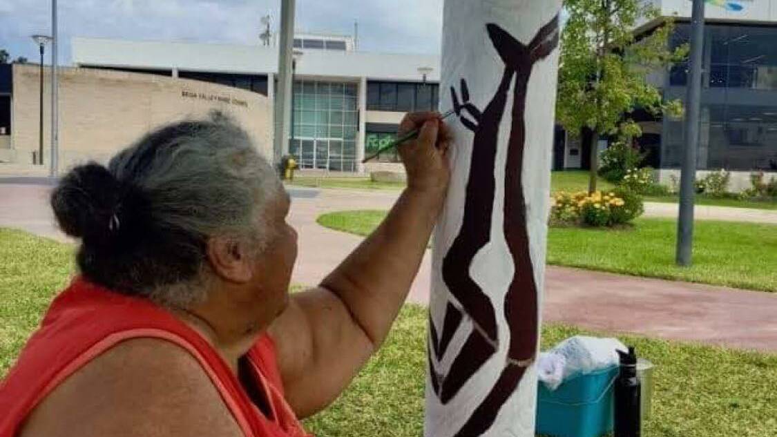 Artist and beloved Djirringanj and Ngarigo Elder, Colleen Dixon, painting the Aboriginal totem poles at Littleton Gardens, Bega. Photo supplied.