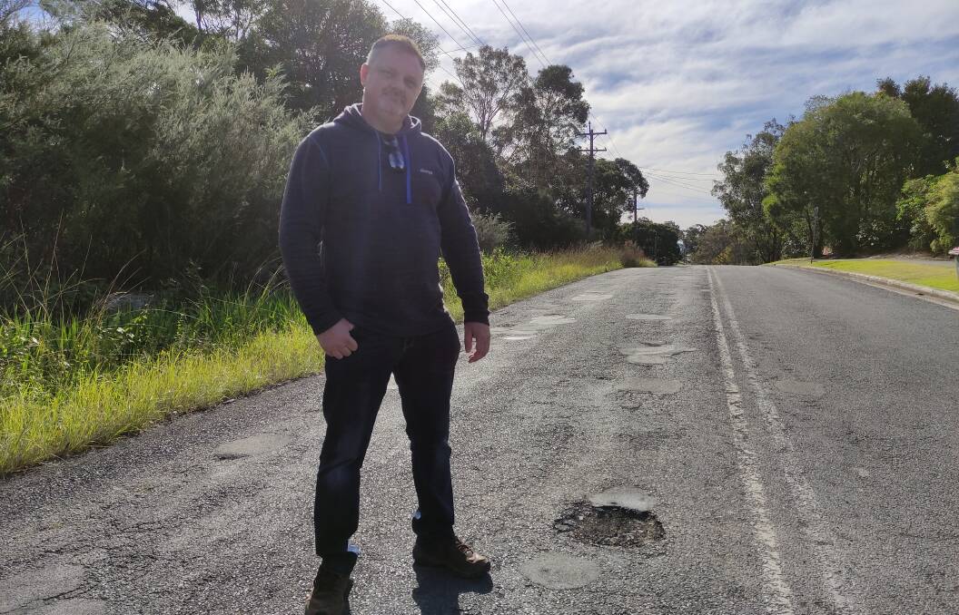 POTHOLE BATTLE: Jason Cox stading at Brinawarr St, one of the rat runs most damaged by frequent traffic.