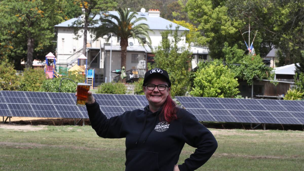 Community manager at the Kangaroo Valley Chamber of Tourism and Commerce Natalie Harker with some of the solar panels that are powering the pub. Picture by Robert Peet