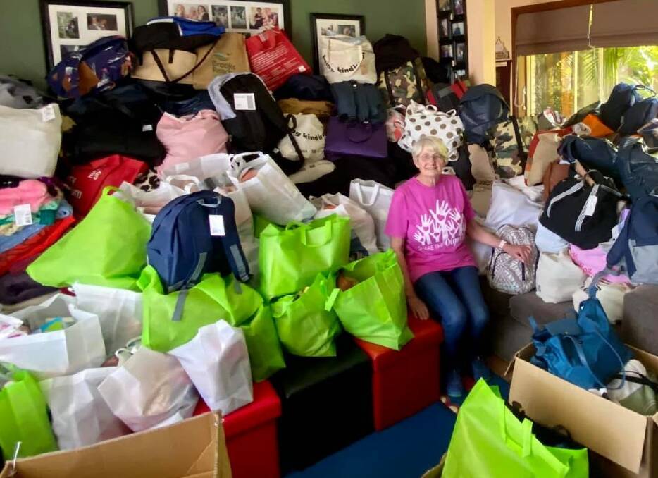 PACKED TO THE RAFTERS: Shirley Edwards in her Sanctuary Point home surrounded by the mountain of bags that will be donated as part of Share the Dignity's Christmas appeal. Image: supplied.