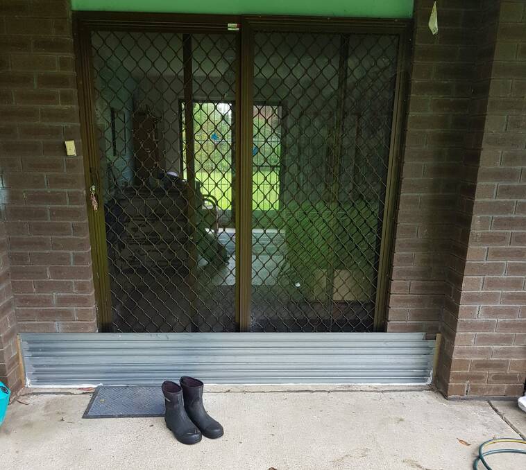 PREPARING: Shoalhaven councillor Evan Christen has created a makeshift flood barrier at his Huskisson home. Image: supplied.