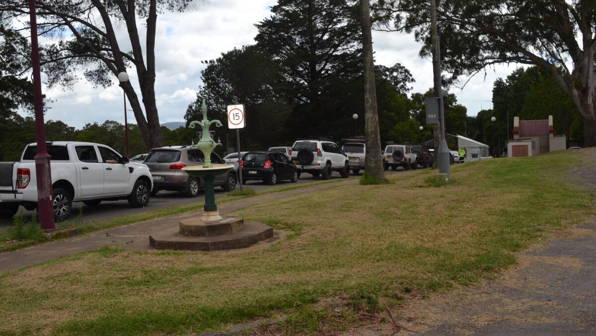 LINEUP: A double line of cars wait at the drive through COVID testing centre at Nowra Showground on Wednesday, with marshals controlling the traffic that snaked back behind the pavilion. Image: Kathy Sharpe.