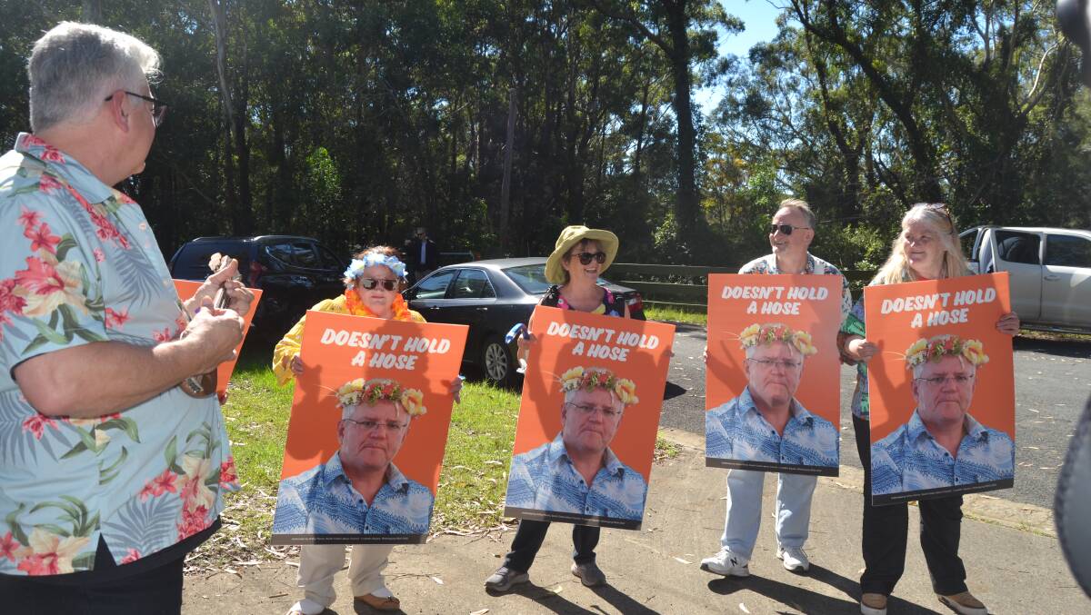 PROTEST: Shoalhaven resident Liz Folkard (far right) was among the small group of protesters outside the Prime Minister's doorstop, where 'April Sun in Cuba' was played followed by a demonstration of 'how to hold a hose'. Image: Grace Crivellaro.