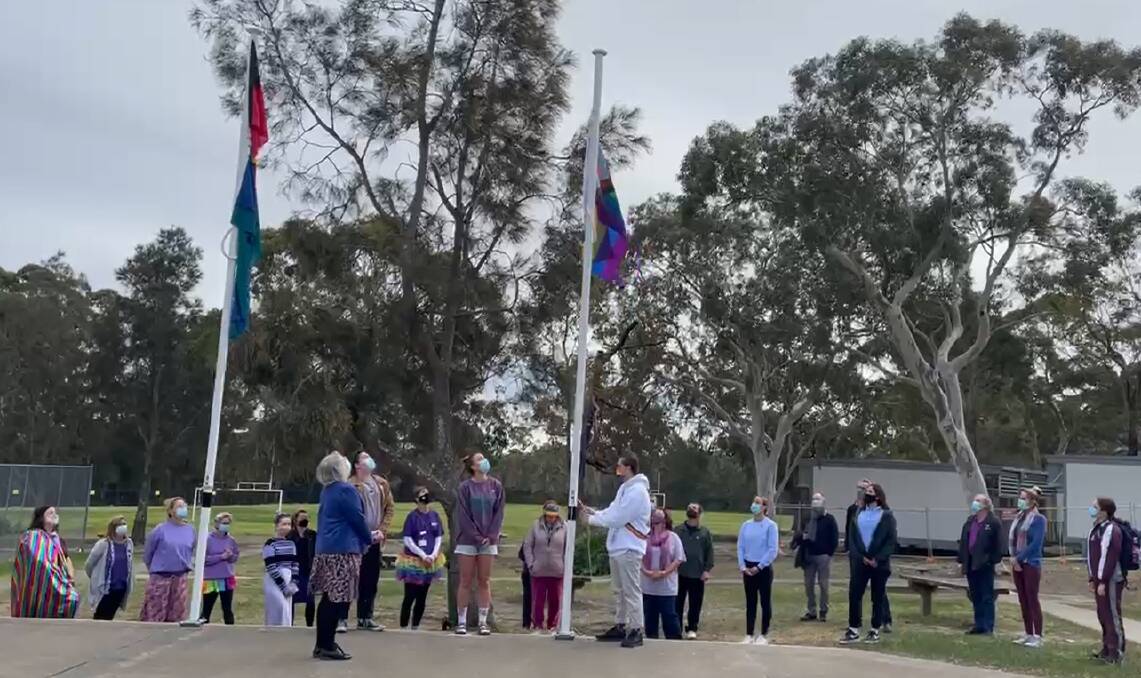 WEAR IT PURPLE: Vincentia High School Student Connor Duffy watched by School Captain Eva Mackay and Senior Leader Harry Axford raise the rainbow flag, with school Principal Ruth Winfield and rostered onsite staff in attendance. Image: supplied.