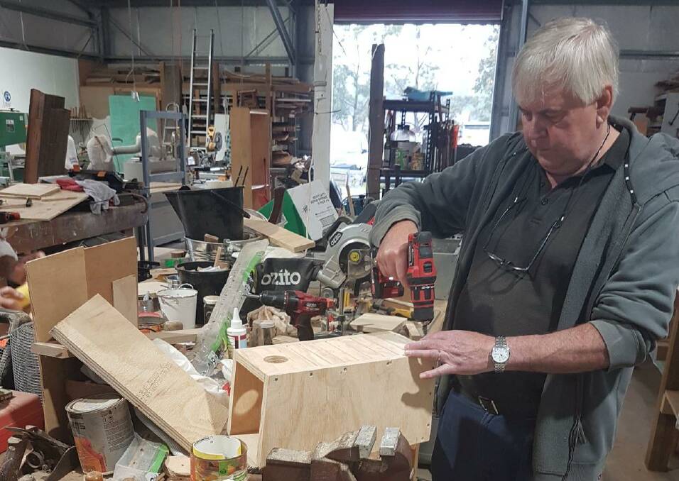 NEW HOMES: A Culburra Beach Men's Shed member working on a bird box. Image: supplied.