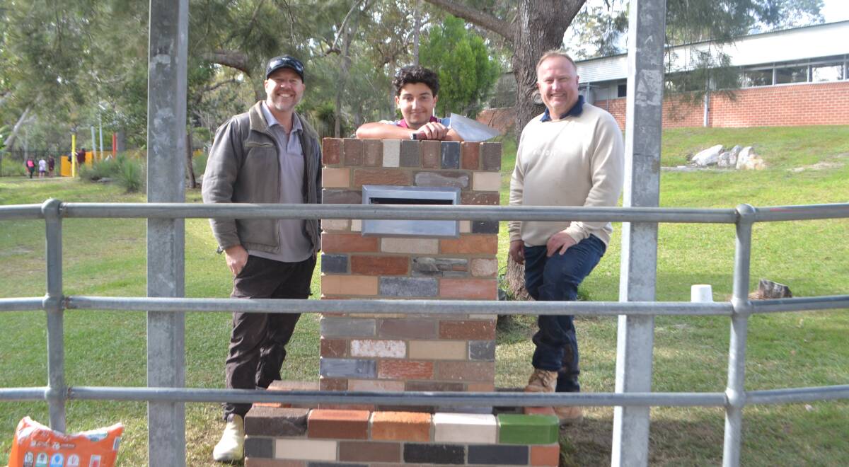 PAVING THE WAY: TAFE NSW bricklaying teachers Brenden Hepper and Troy Everett with Vincentia High School year 11 student Jayden Muscat and their finished product - a suggestion box.