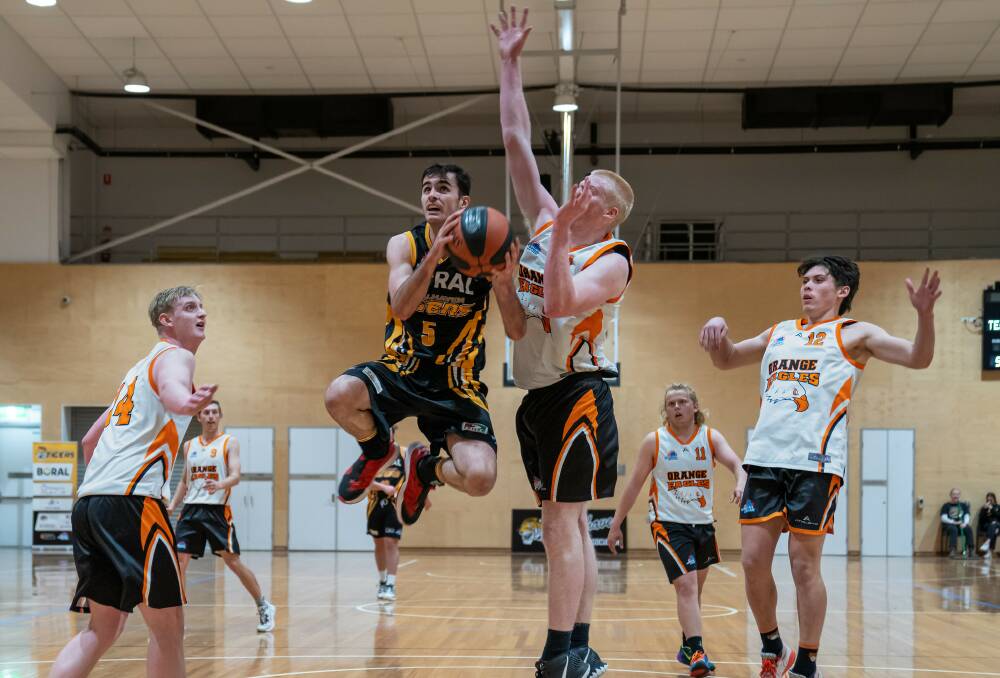 STYLE POINTS: Jordan Bandur going for an acrobatic layup against Orange's Andrew Gogala. Picture: Shoalhaven Basketball Association. 