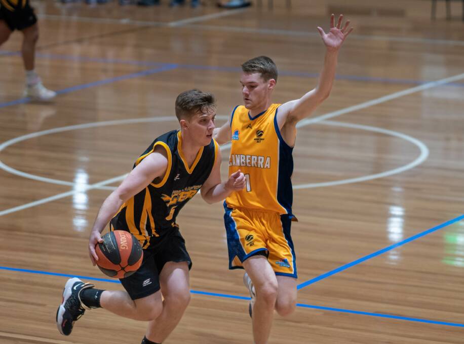 BREAKING DOWN THE DEFENSE: Tigers Guard, Joshua Watts being hounded by Canberra's Mitchell Robinson. Picture: Shoalhaven Basketball Association.