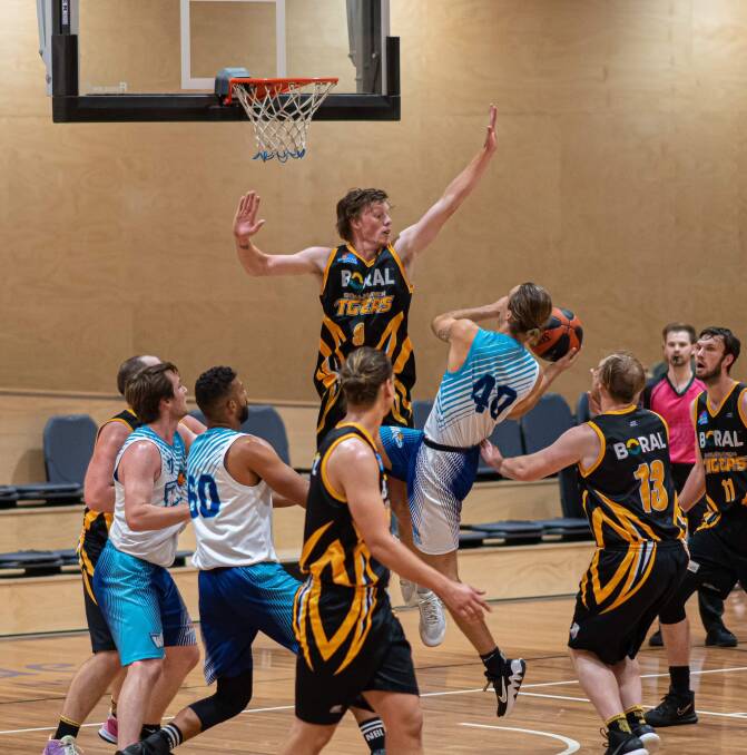 DEFENSE FIRST: Tigers #9 Zachary Ottosson defending the rim against Waves #40 Harry Fortey. Picture: Shoalhaven Basketball Association. 